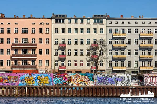 Hausfassade mit Berliner Mauer an der Spree - Bild auf Leinwand, Acrylglas oder Alu-Dibond