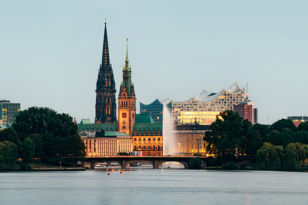 Leuchtende Wahrzeichen - Blick über die Außenalster auf das Rathaus, die Elbphilharmonie und die Nikolaikirche in Hamburg, Bild auf Leinwand, Acrylglas oder als Poster